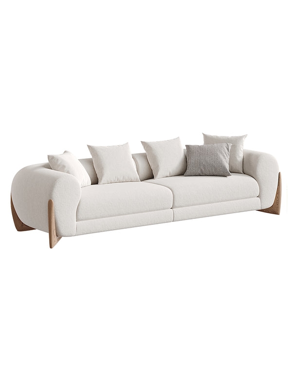 A modern luxury sofa with soft curved design, upholstered in elegant fabric with wooden side accents, EVOCA Sofa by INSIDE HOME.