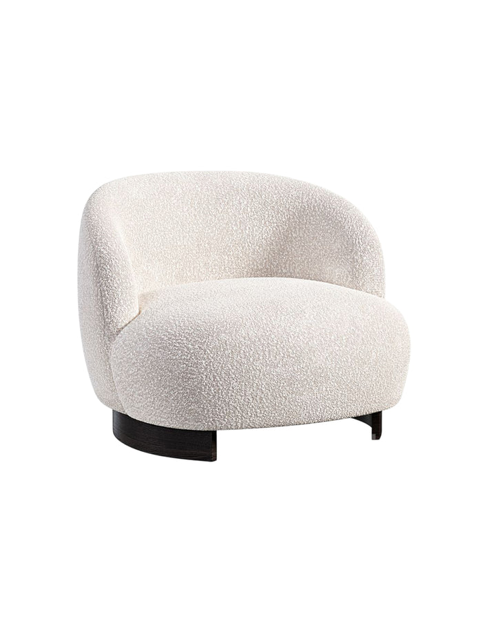Side angle of Marcel Armchair highlighting curved backrest and plush seating.