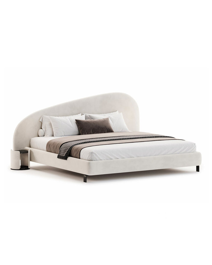 Minimalist luxury upholstered bed with asymmetrical curved headboard in soft beige tones – Calma Bed by INSIDE HOME.