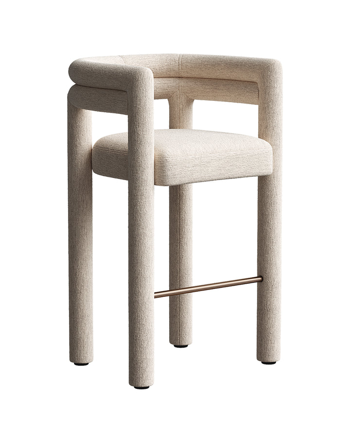 VOLNIA bar chair with fully upholstered cylindrical frame, soft fabric texture, and bronze footrest by INSIDE HOME.